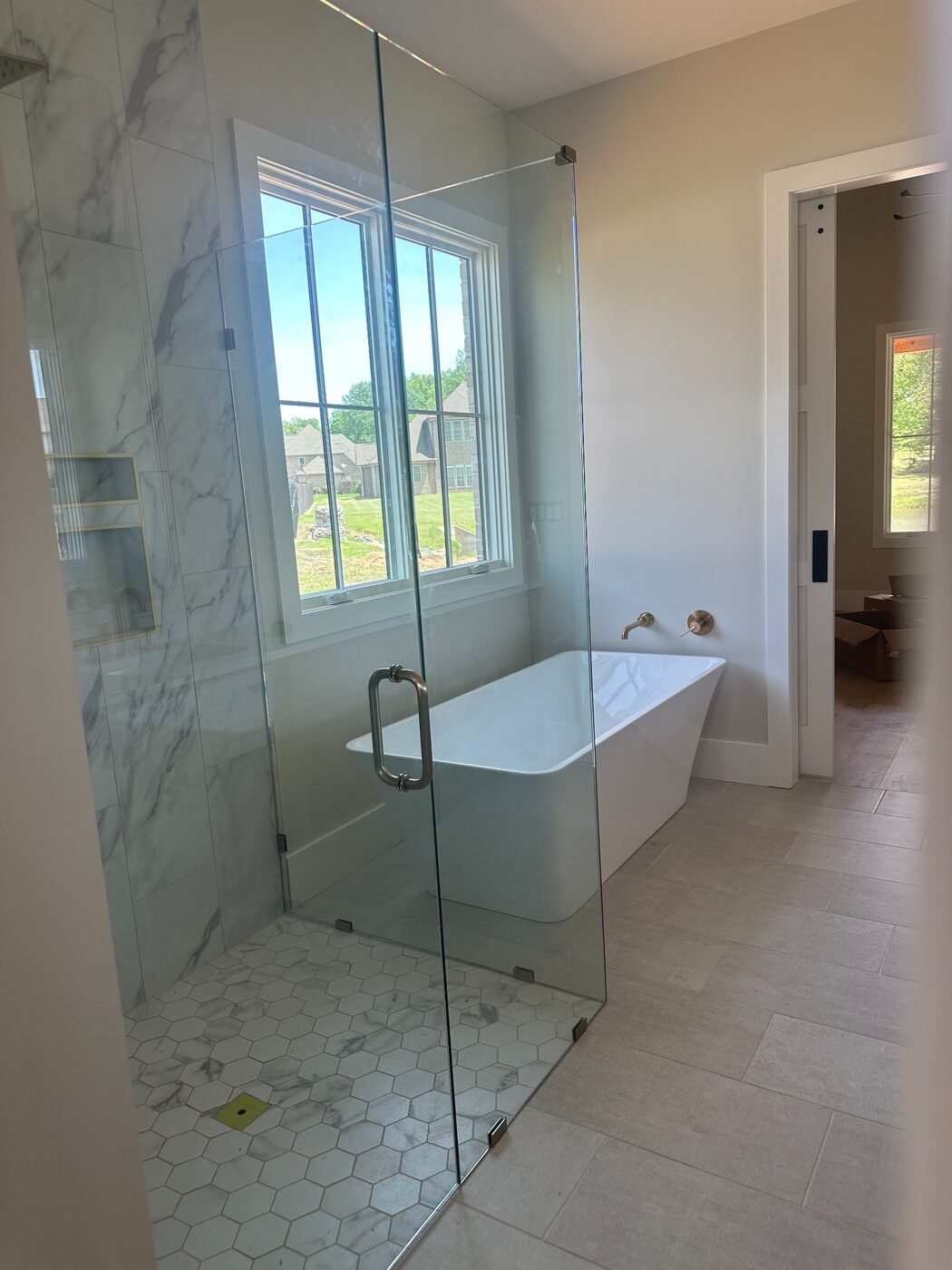 Frameless corner shower beside a freestanding tub